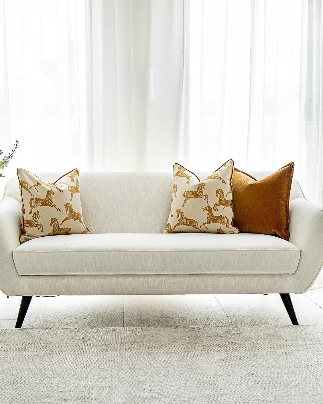 Arie Bundle cushion in orange and beige, shown in a lifestyle front view as image 4