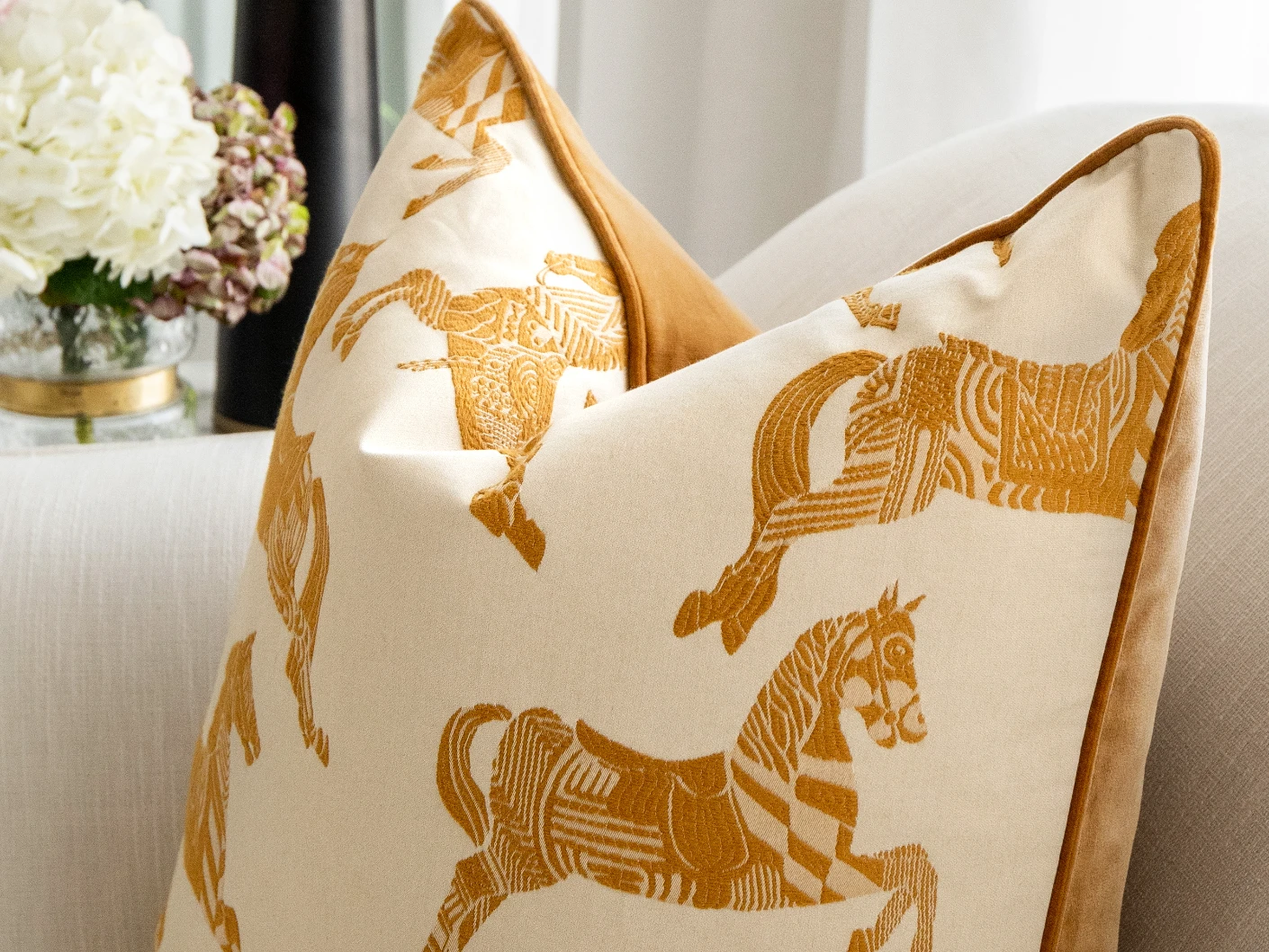 Arie Bundle bundle cushions in orange and beige, shown in a lifestyle close-up front view
