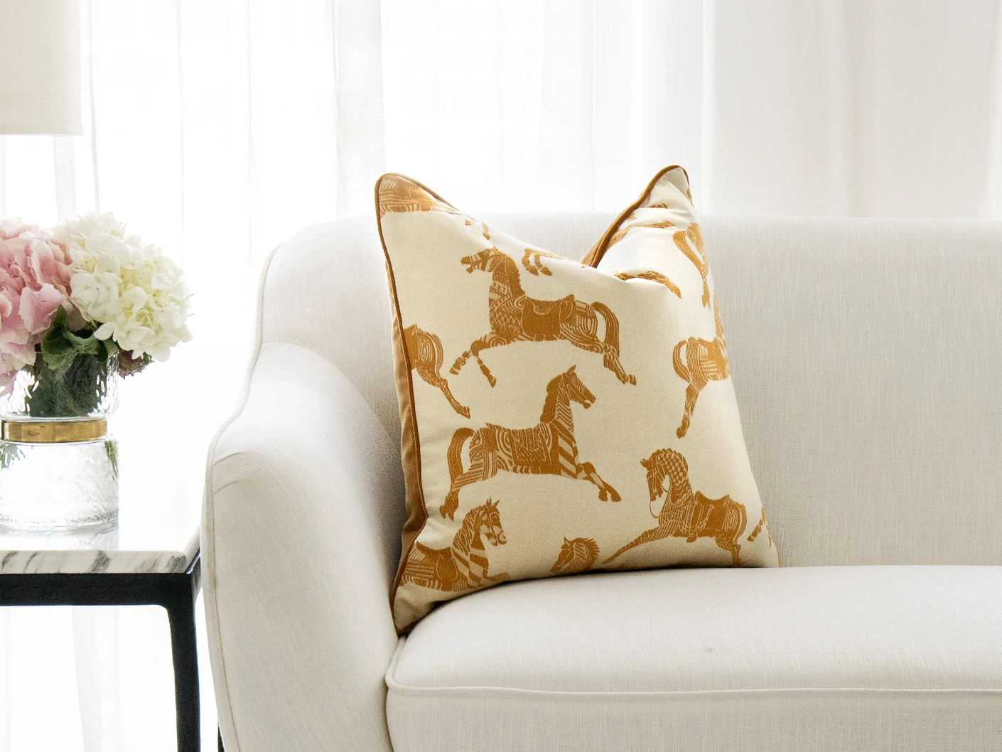 Aurora Klimt single cushions in orange and beige, shown in a lifestyle front view