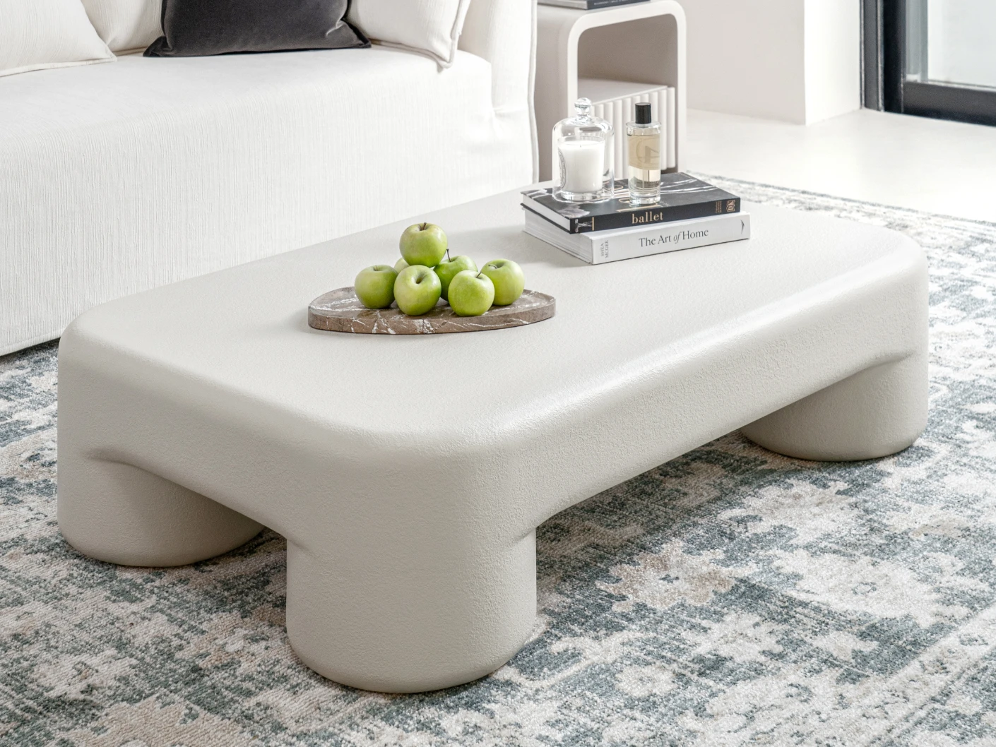Bari coffee table in soft ivory and stone, shown in a lifestyle left view