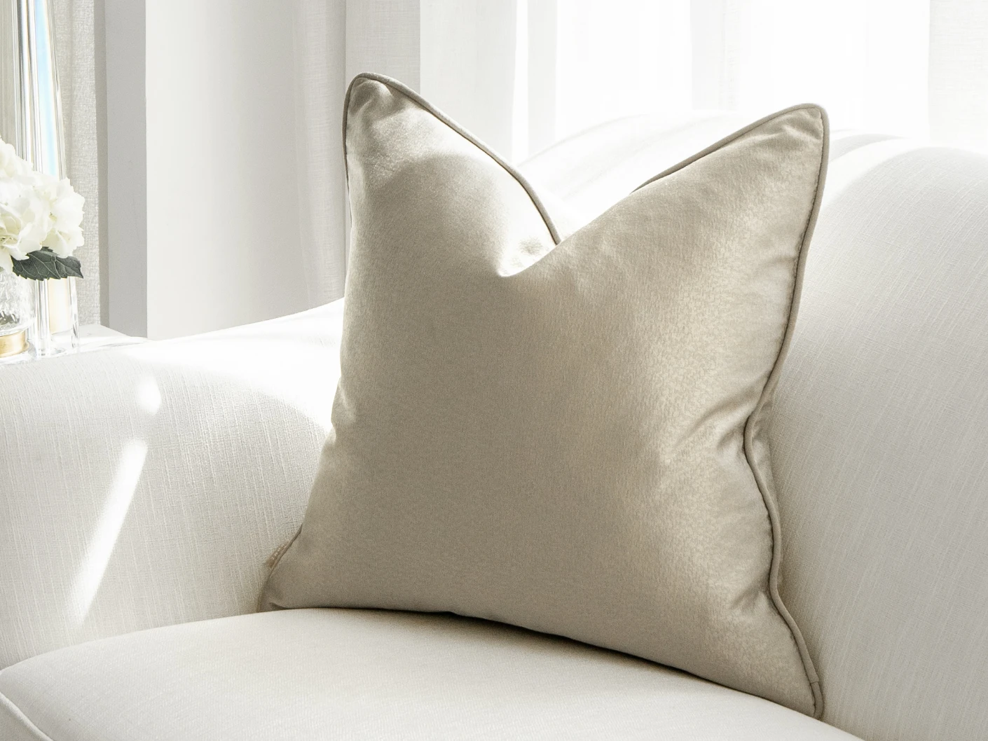 Celeste Laurent single cushions in gold and beige, shown in a lifestyle front view