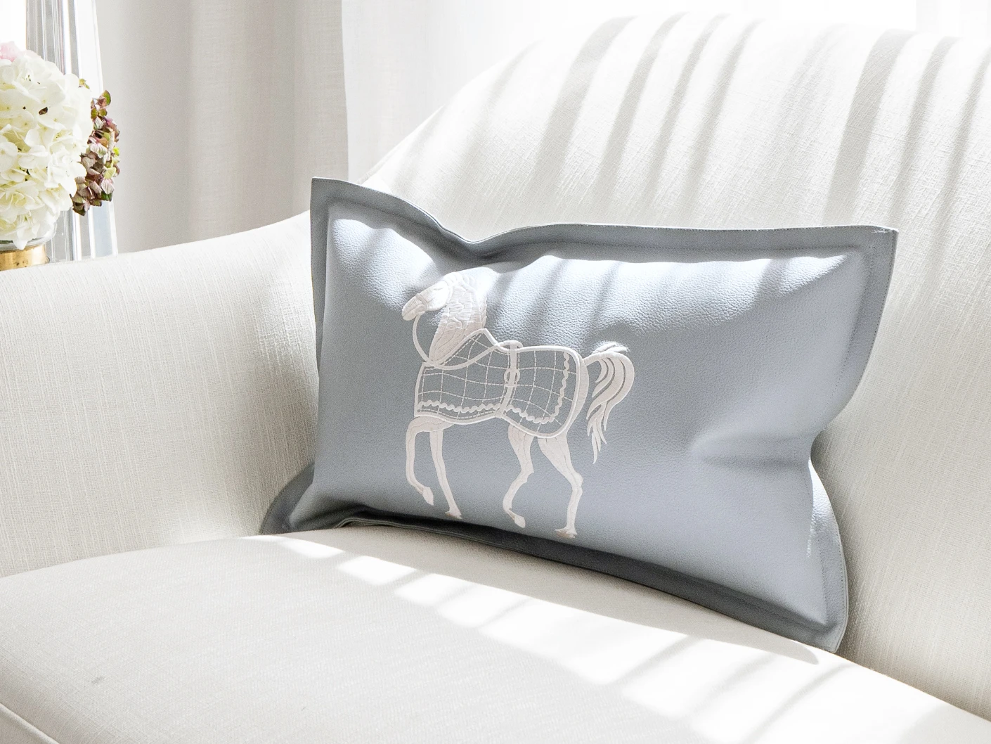Filip Matisse single cushions in blue and white, shown in a lifestyle front view
