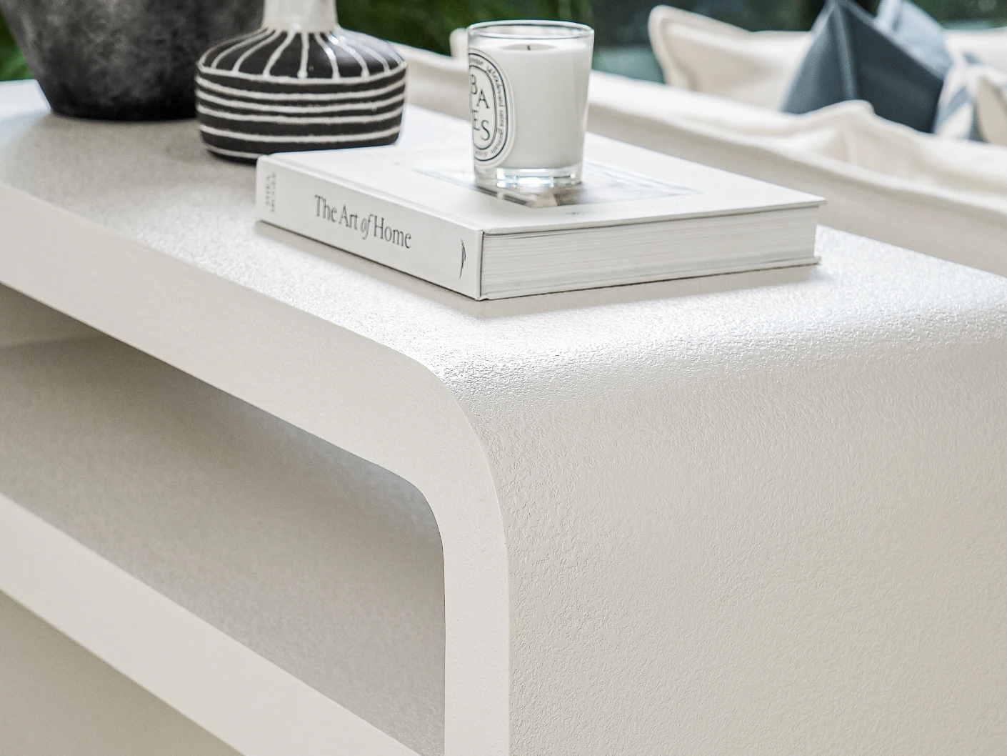 Orta console table in soft ivory and stone, shown in a lifestyle right view