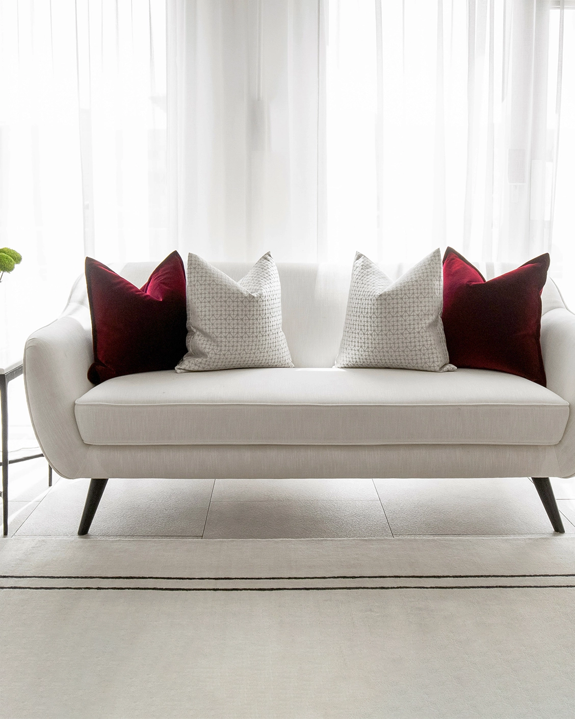 Cerise Bundle cushion in red, silver and white, shown in a lifestyle front view as image 4
