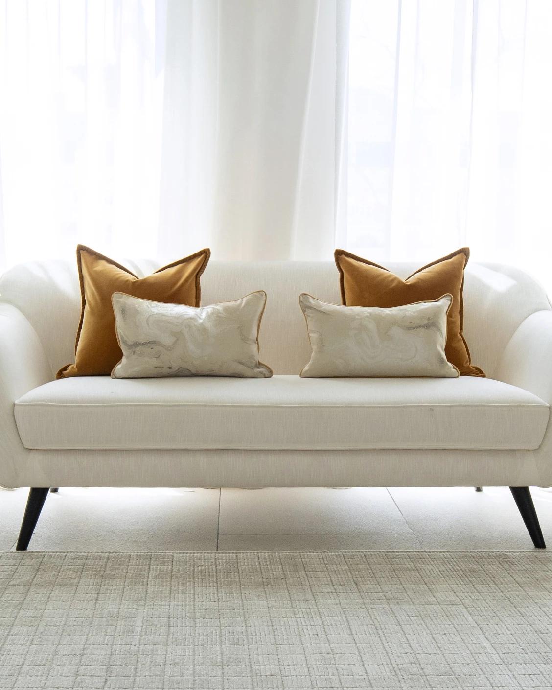 Johan Bundle cushion in orange, silver and yellow, shown in a lifestyle front view as image 4